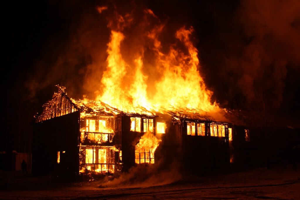 a house is on fire and burning against a dark background