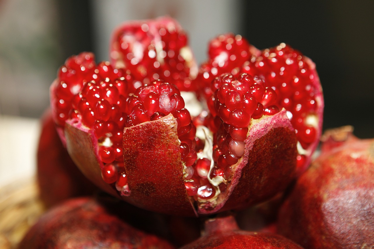 Close-up of a halved pomegranate displaying its juicy red seeds.