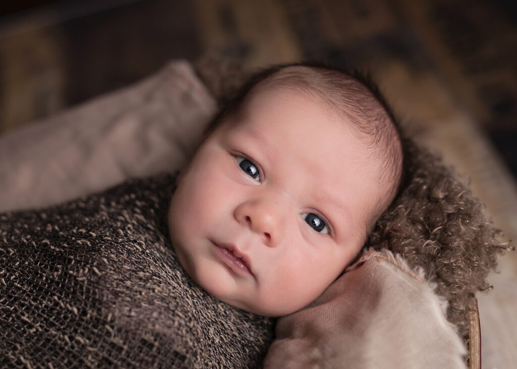 baby bundled in brown knitted fabric