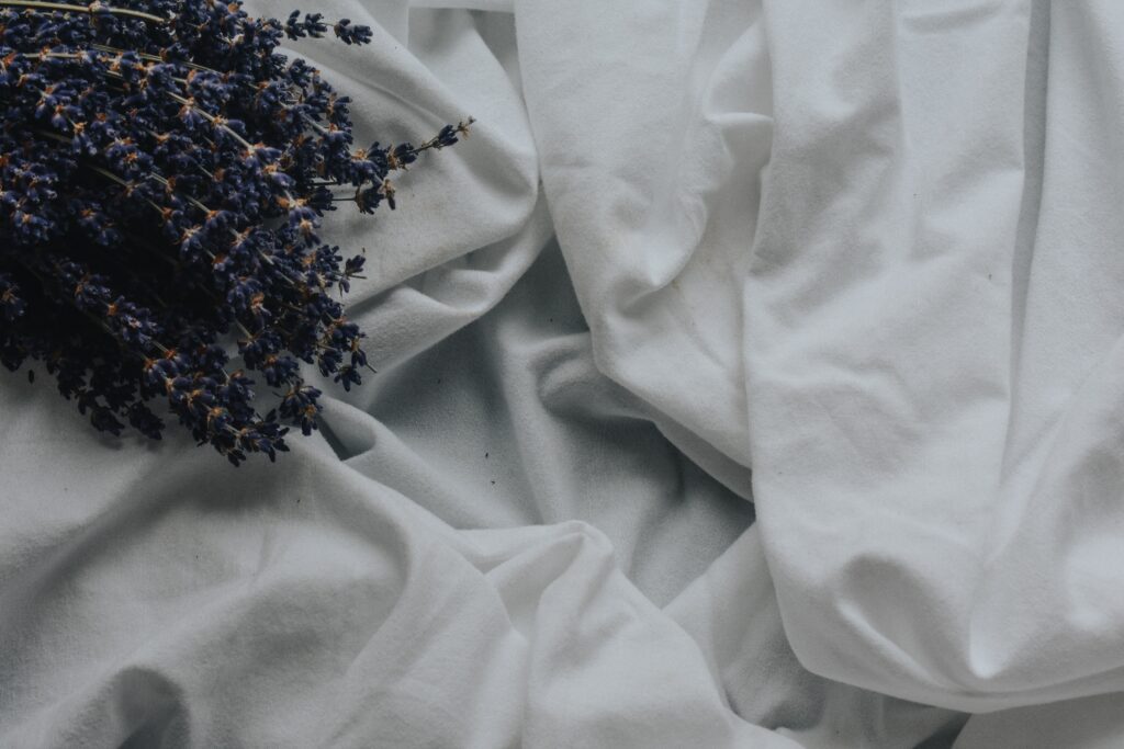 white sheet and dried purple flowers