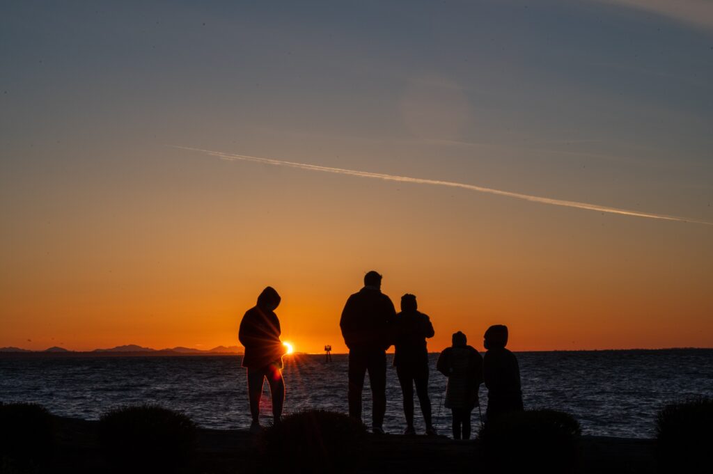 family at sunset silhouetted on the beach