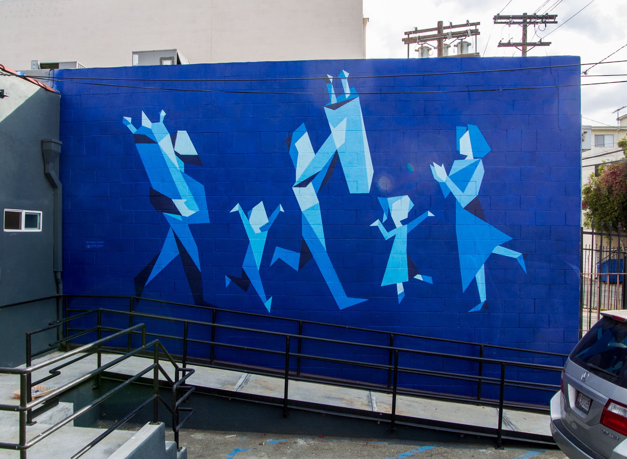 a blue mural of people dancing with Torah scrolls