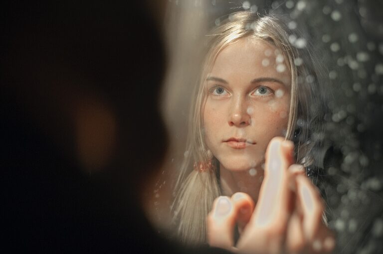 blond woman's face looking in the mirror