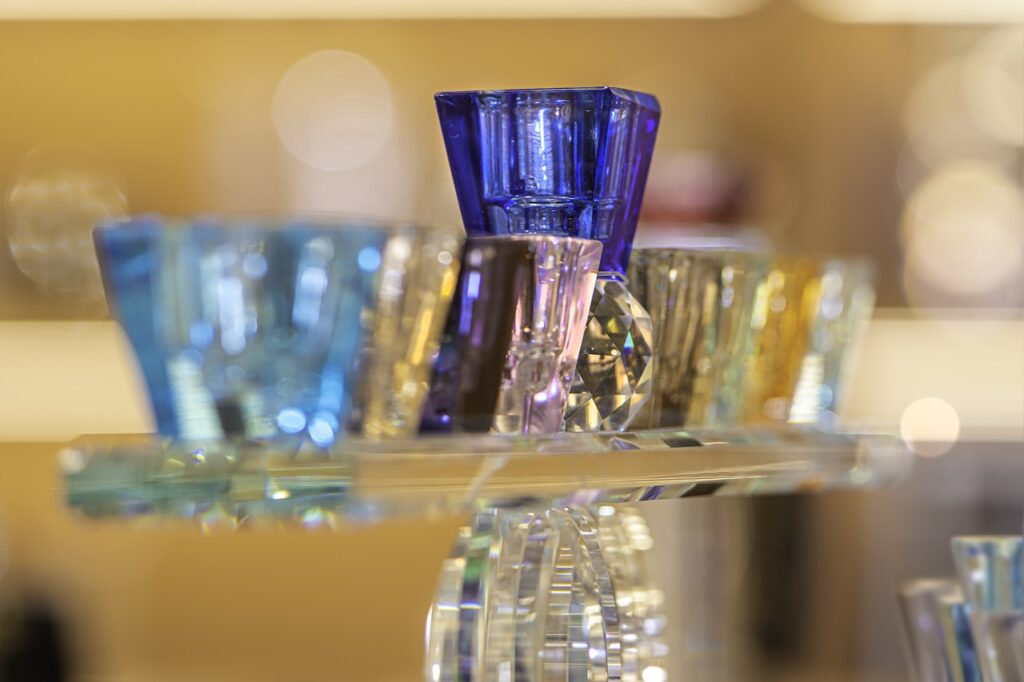 a close-up of a glass hanukkah menorah featuring different colored glass candle holders