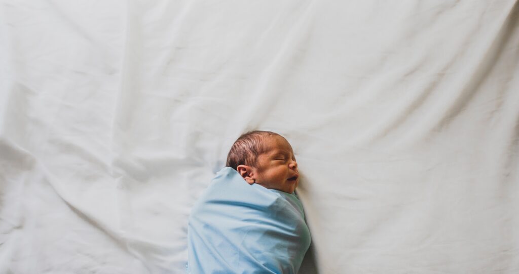 newborn baby wrapped in blue blanket