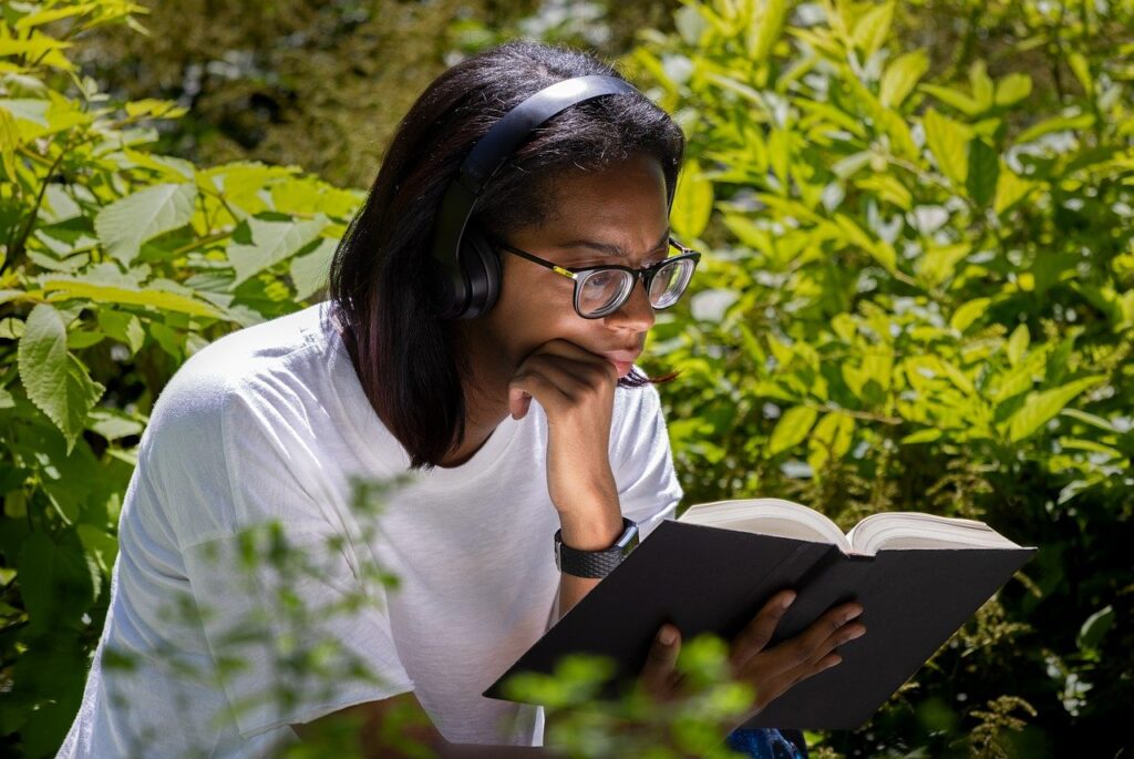 a person sits in a garden reading a book