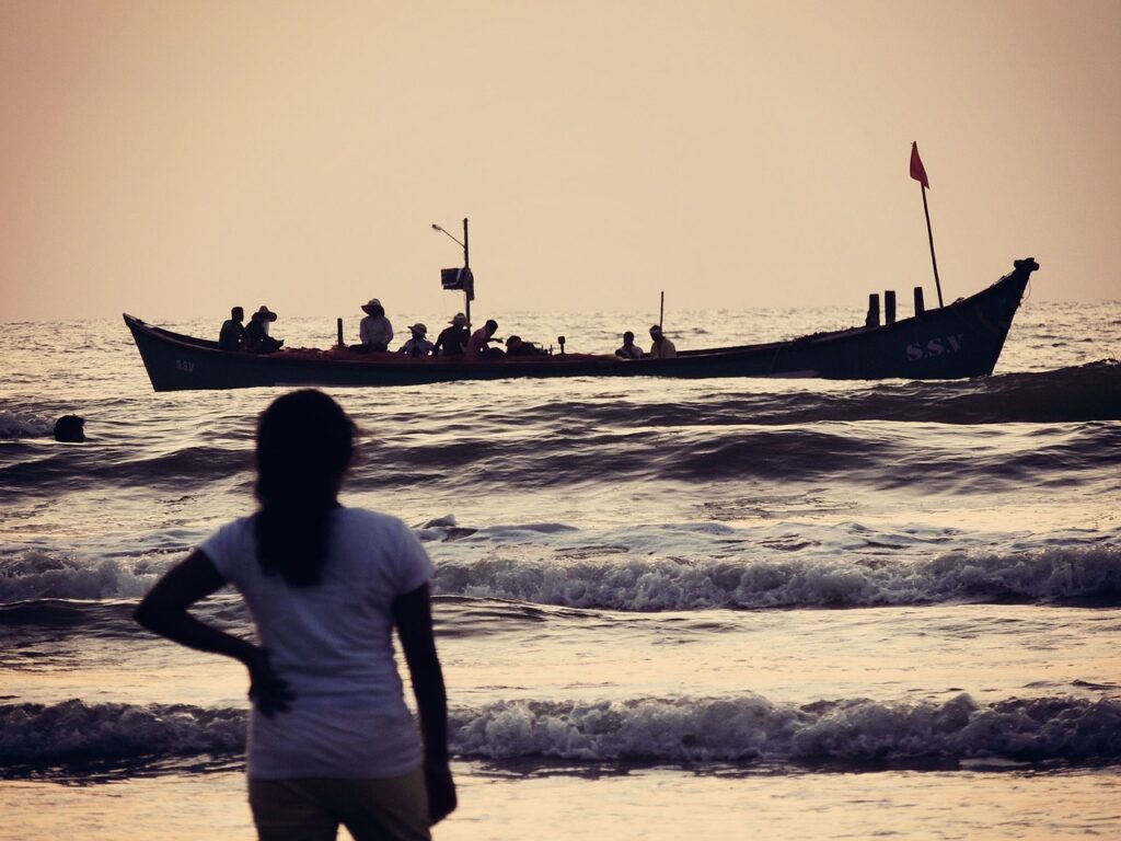 a person looks out at a boat on the water