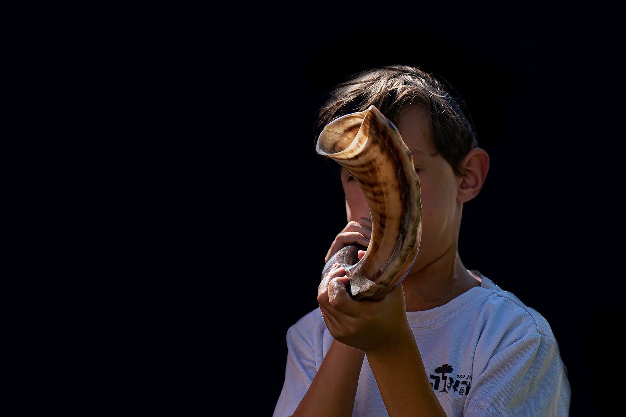 a young person blows a shofar