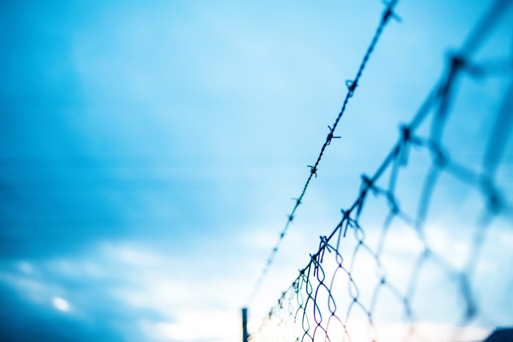 close up of border fence against bright blue sky