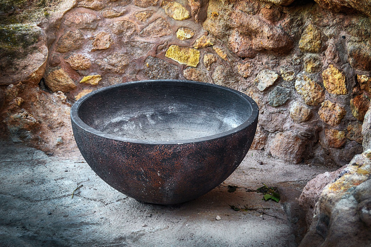 a dark grey ceramic bowl sits on a flat stone surface