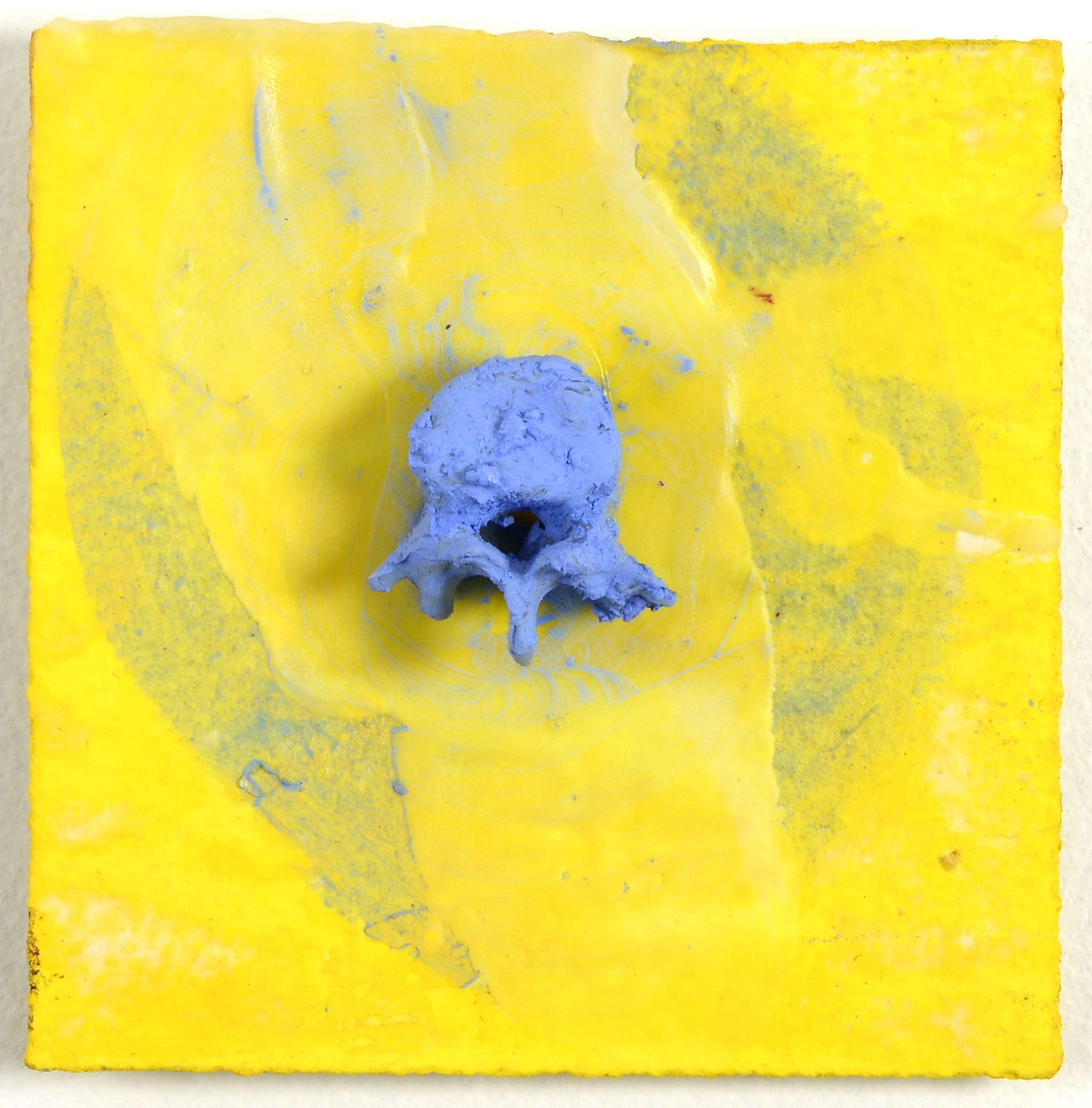 Abstract artwork: a blue skull-like sculpture on textured yellow canvas with blue brushstrokes.