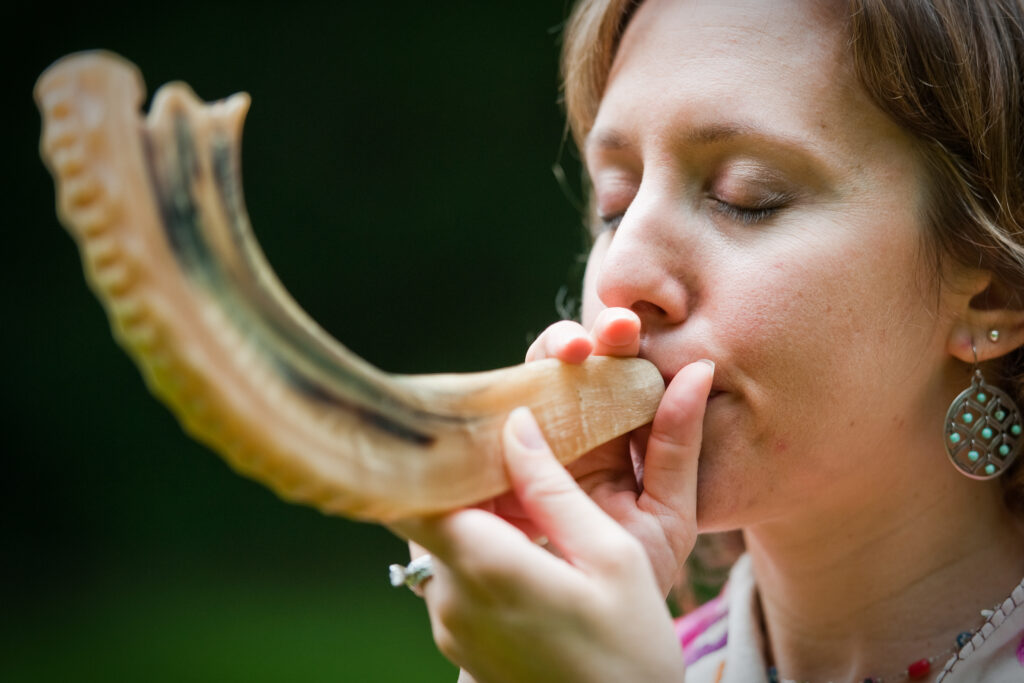 a person is blowing a shofar