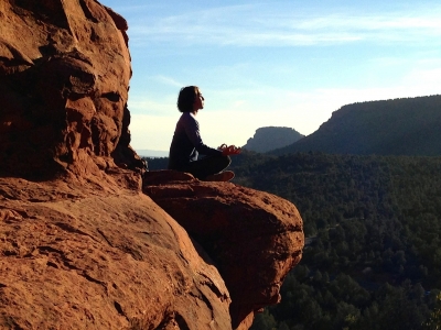 a person sits on a rock in the desert