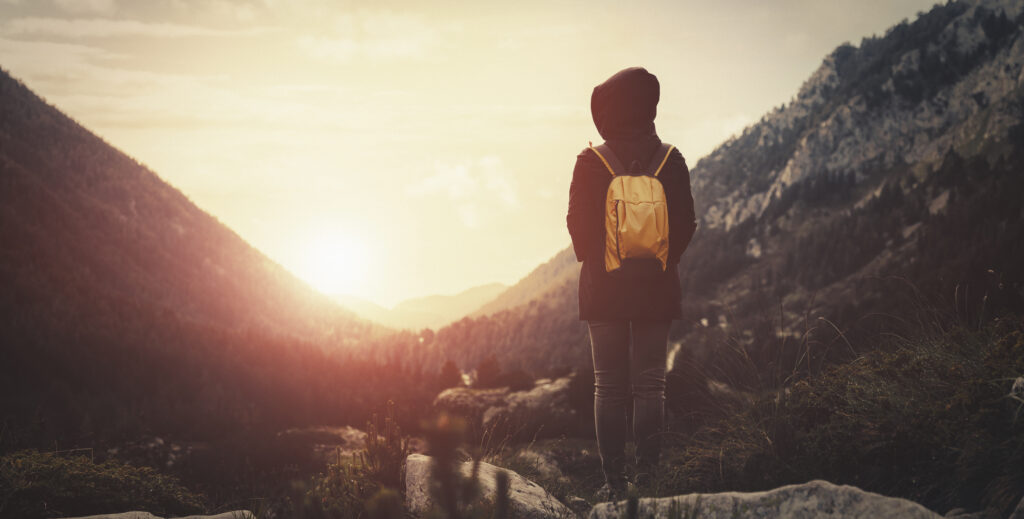 a person walks towards a sunset in the valley