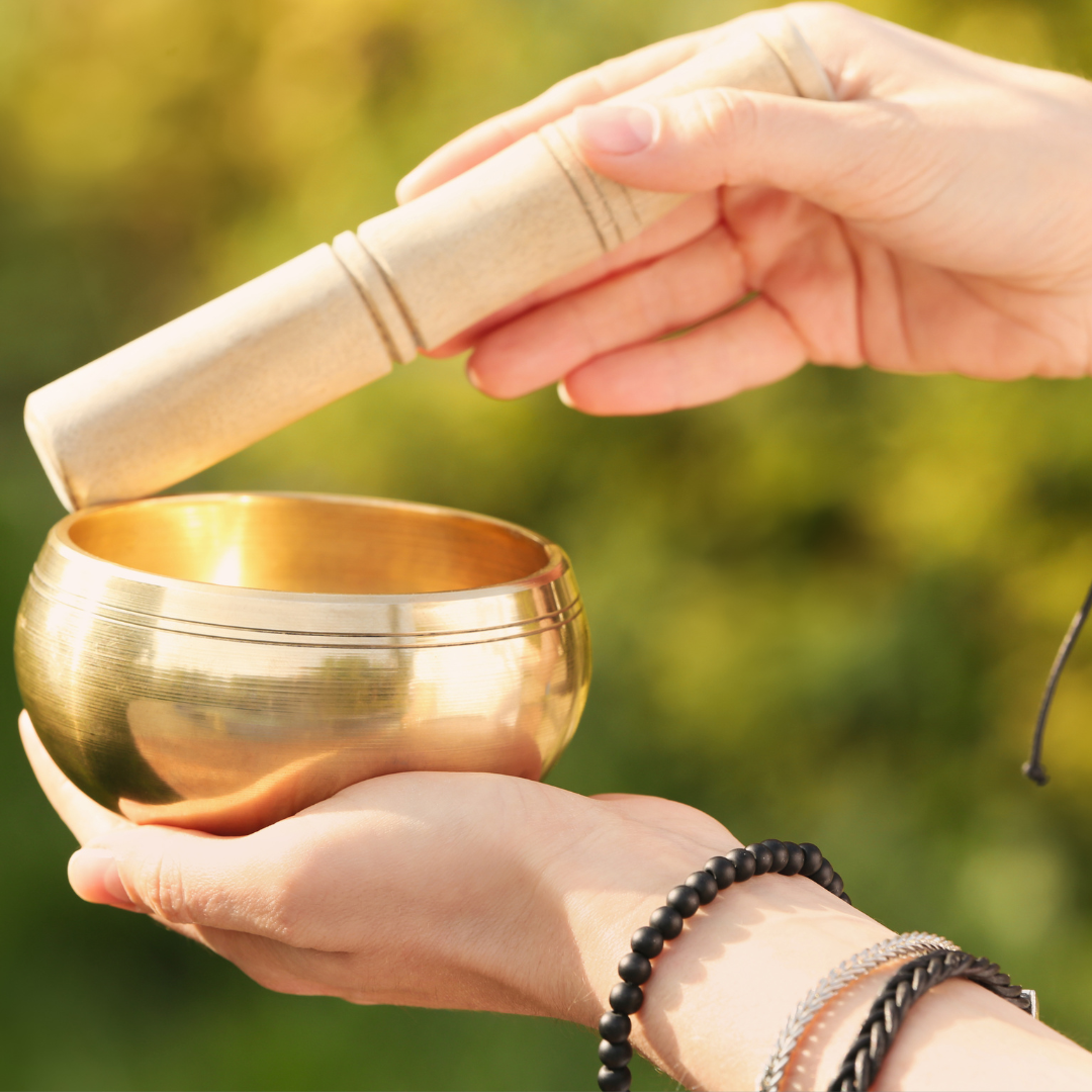 a singing tibetan prayer bowl in woman's hand