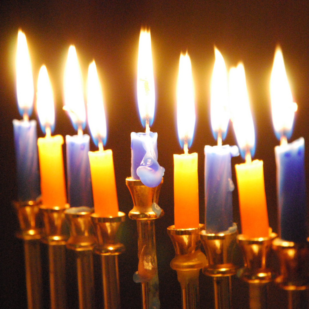 A menorah with nine lit candles, glowing against a dark background.