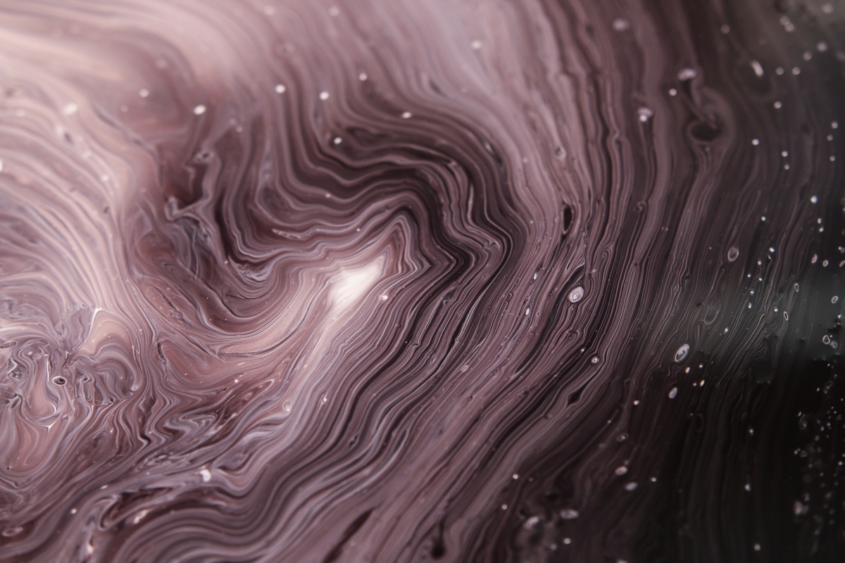 Close-up of swirling pink and black marbled patterns with a glossy texture, resembling liquid or abstract art.