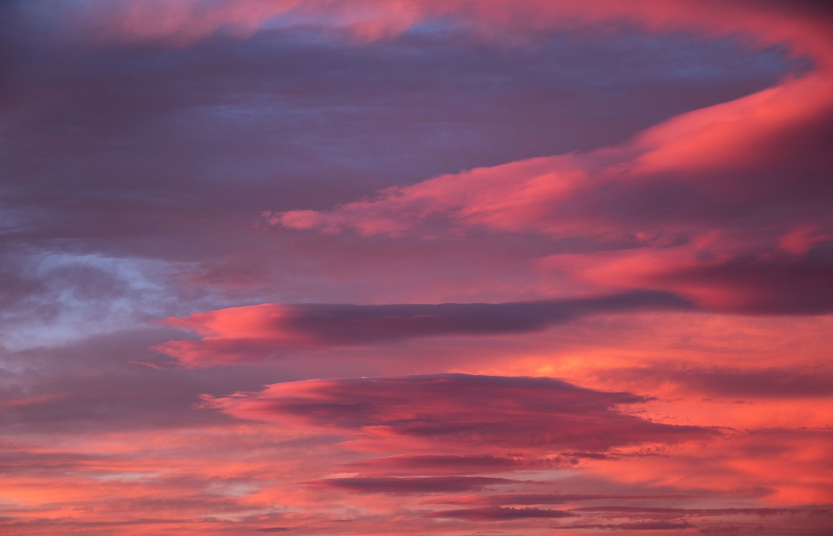 Vibrant sunset sky with shades of pink, orange, and purple clouds.