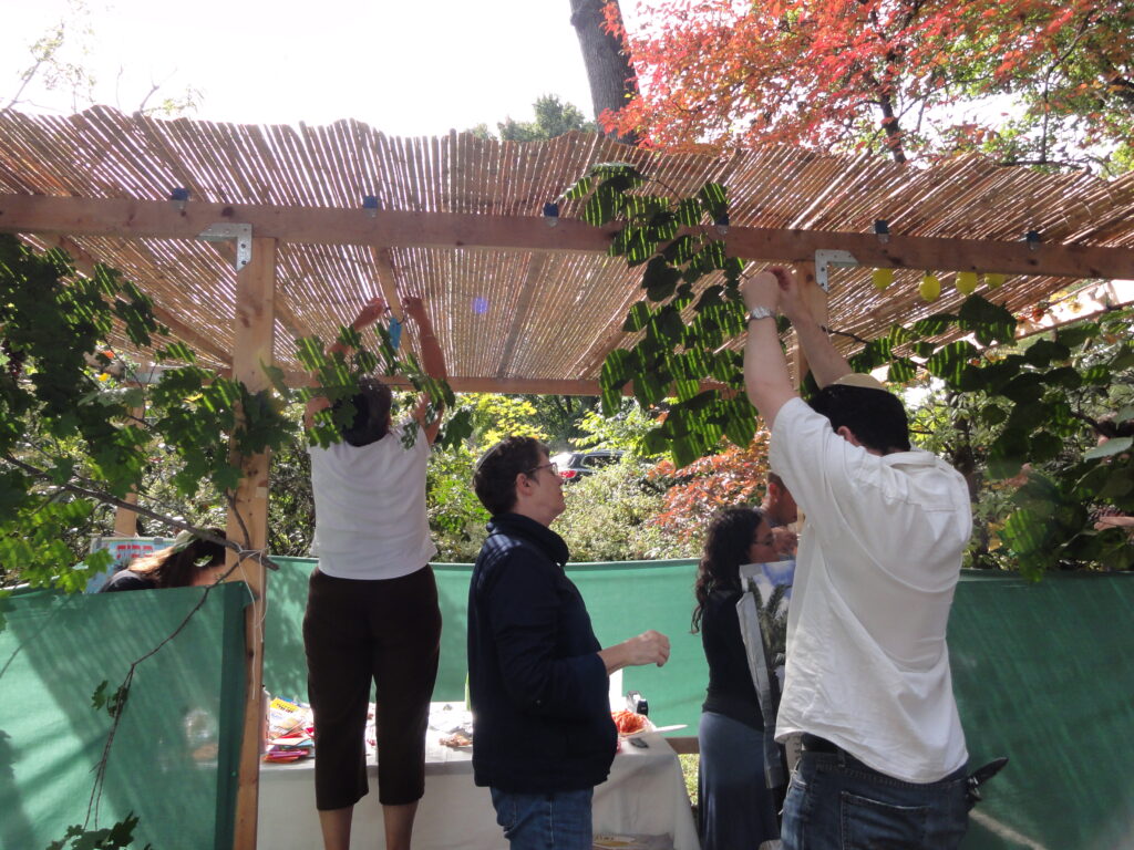 group of people decorating a sukkah
