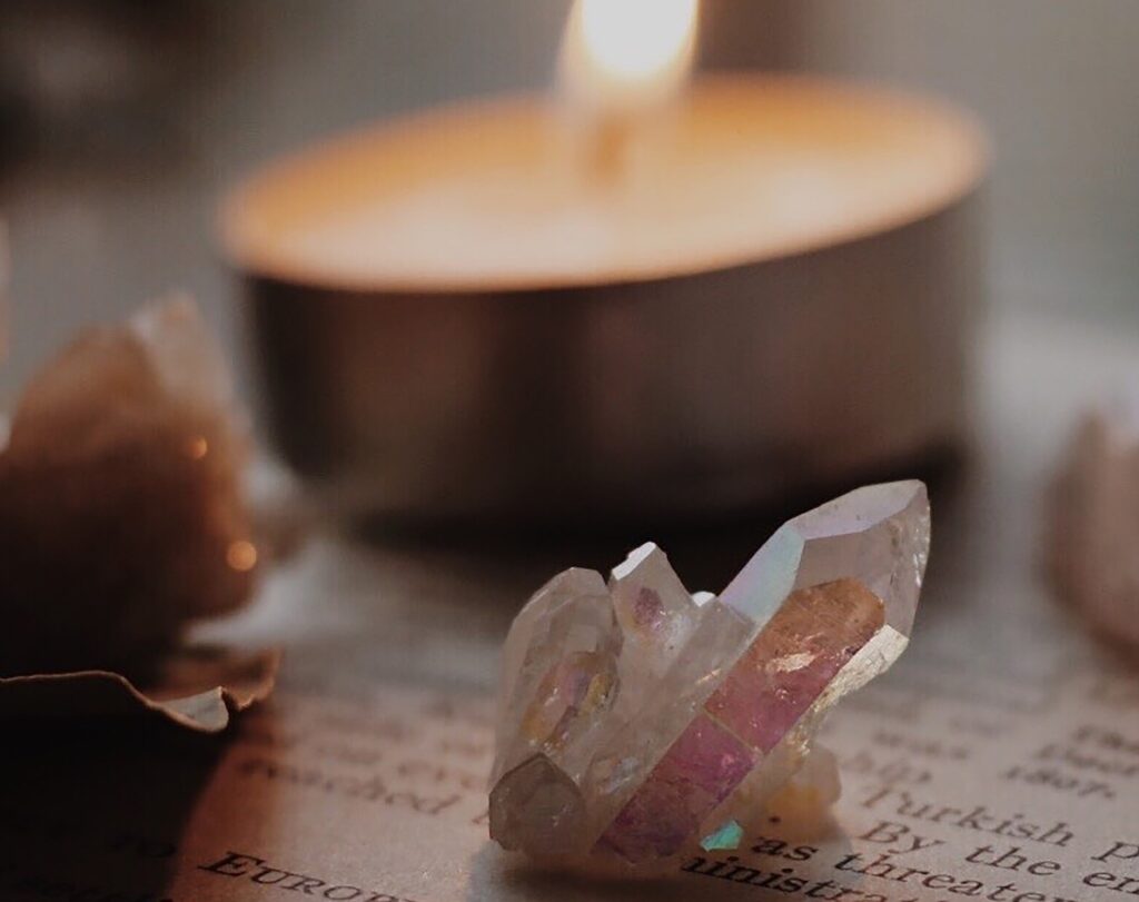 closeup of crystal with lit tea light in background on paper with typed words