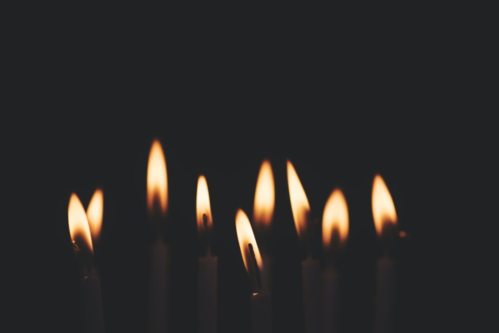 nine candles lit against black background