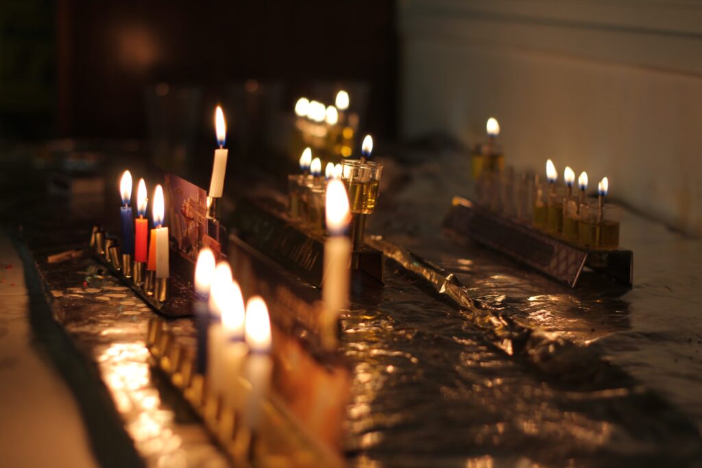 group of lit menorahs shining in the dark