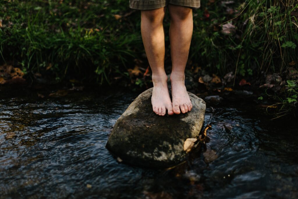 bare feet on a rock in a stream