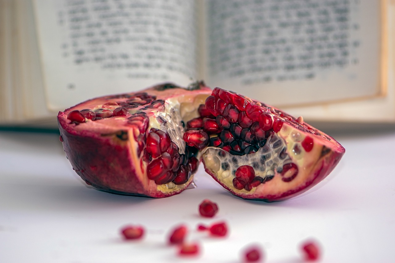 a pomegranate sitting in front of a prayerbook