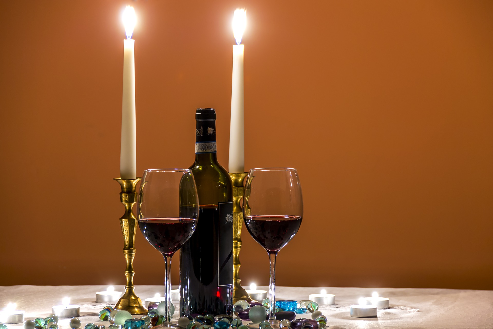 Shabbat candles and wine set on a white tablecloth