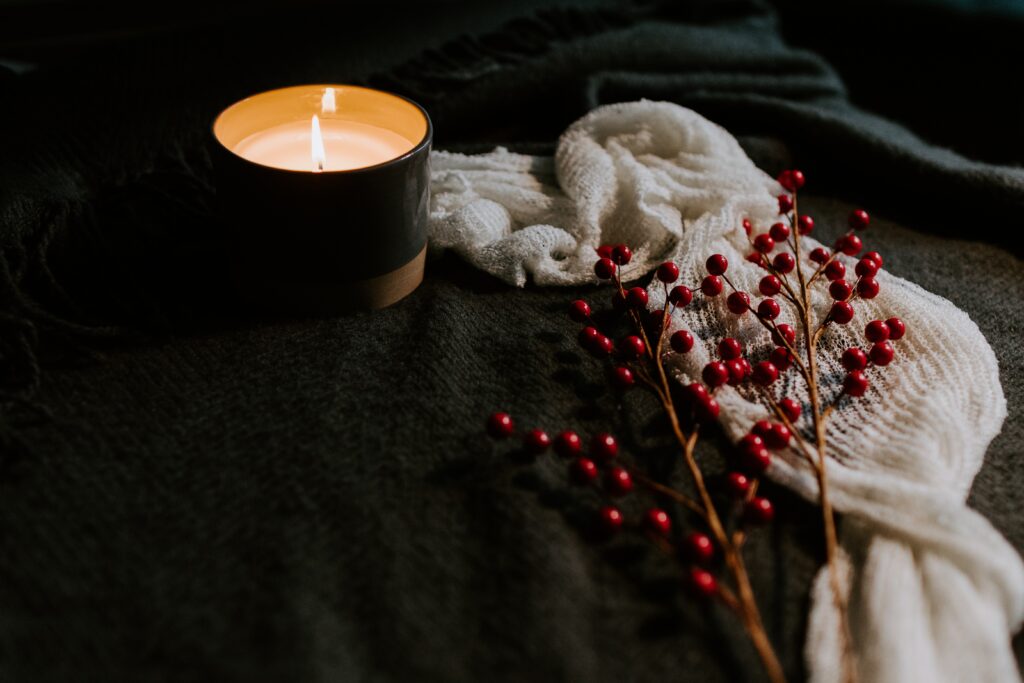 a candle and red flowers