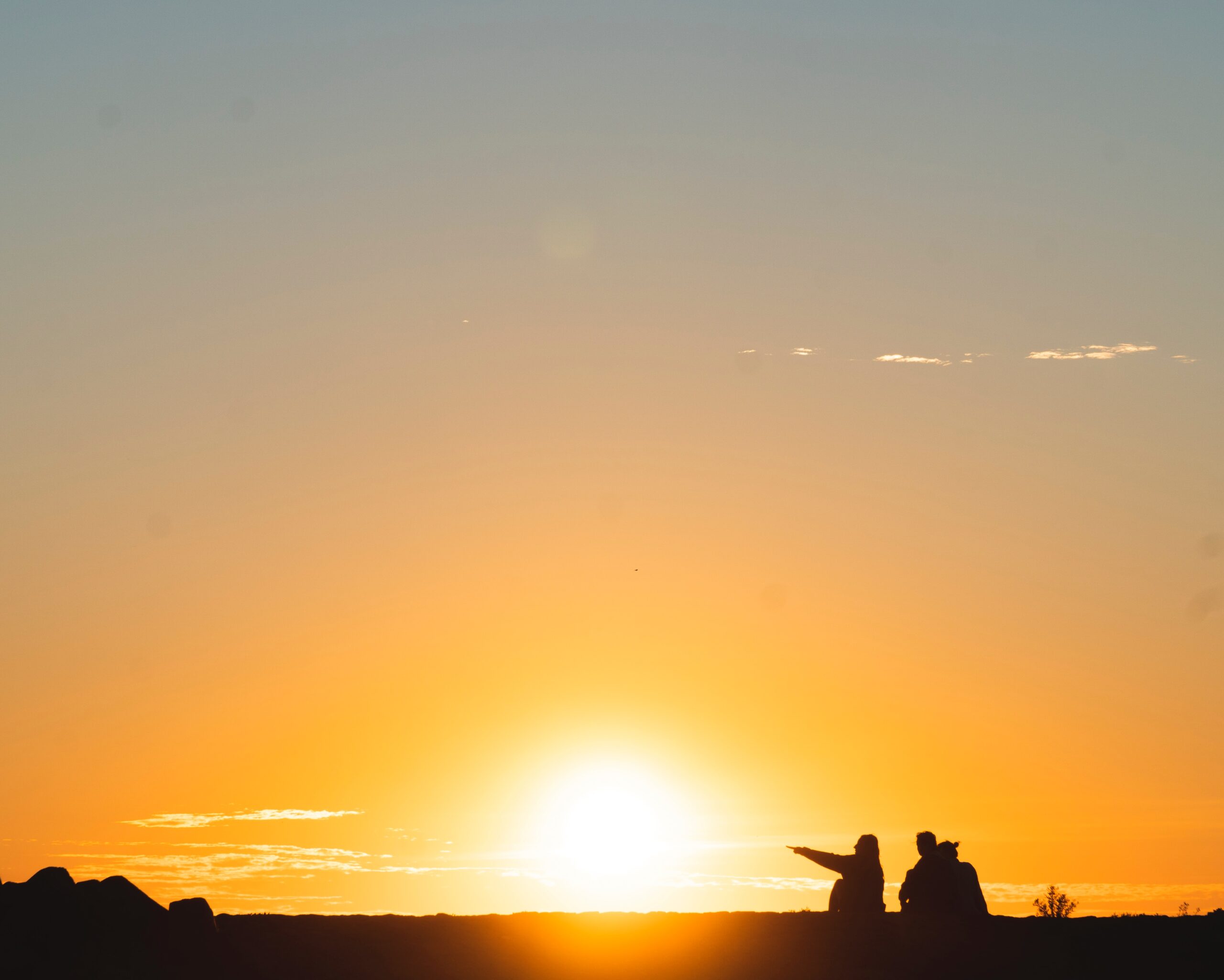 people in the wilderness pointing to the sunrise