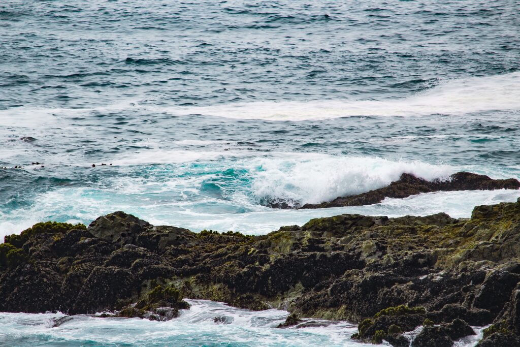 rocks in the ocean, small waves crashing