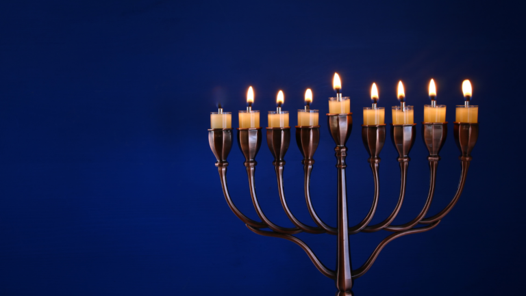 a hanukkan menorah with all lights lit but the eighth candle