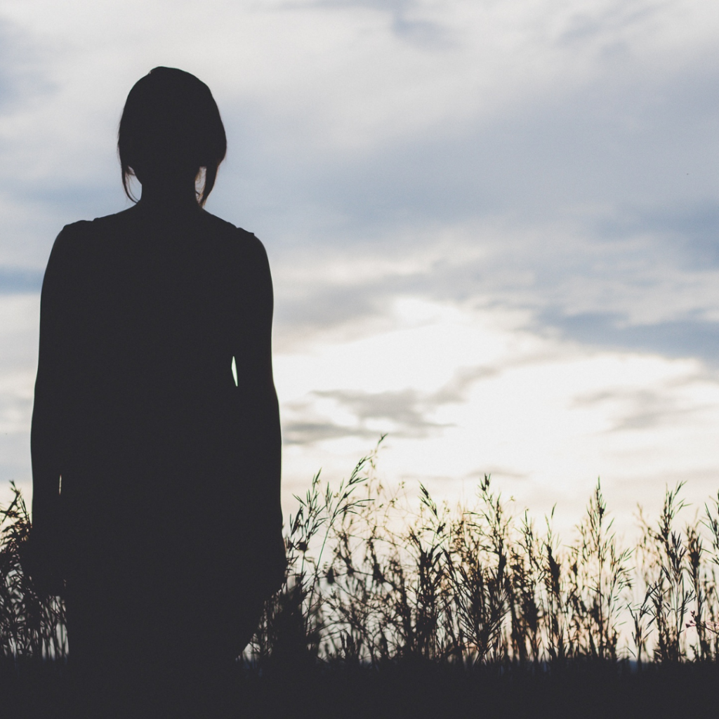 a woman stands looking into the sky