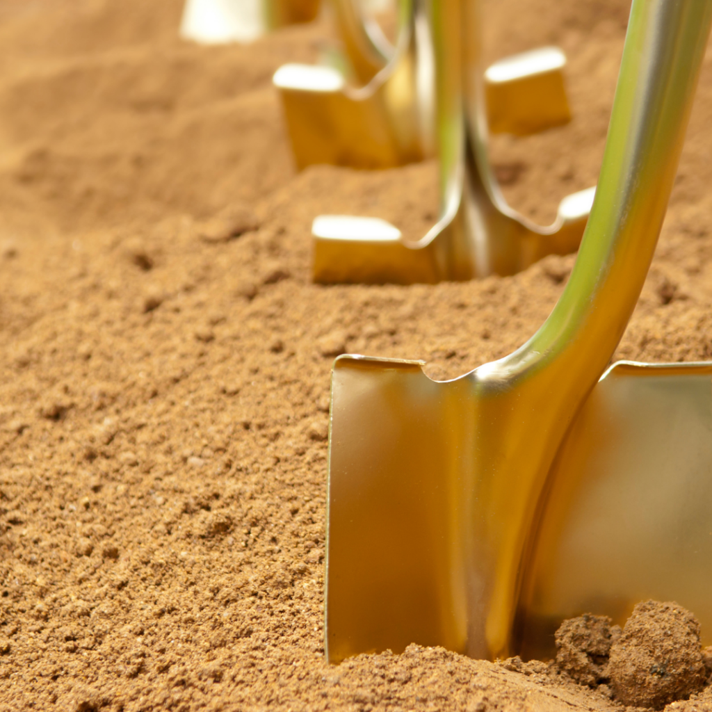 a golden shovel digs into the dirt