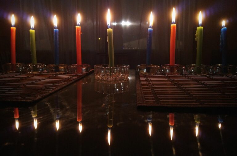 Hanukkah candles lit in two hanukkiyot