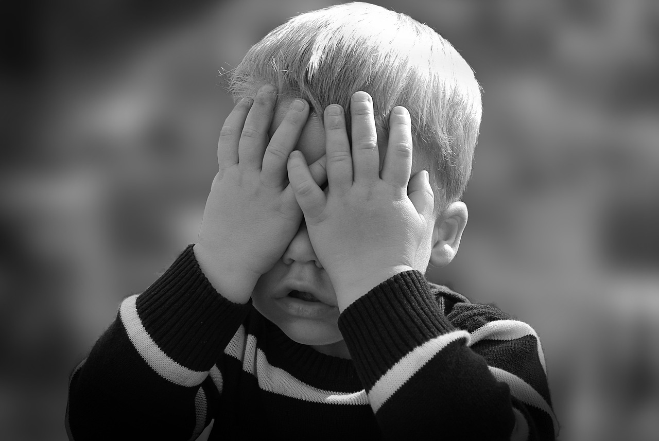 a child covers his eyes