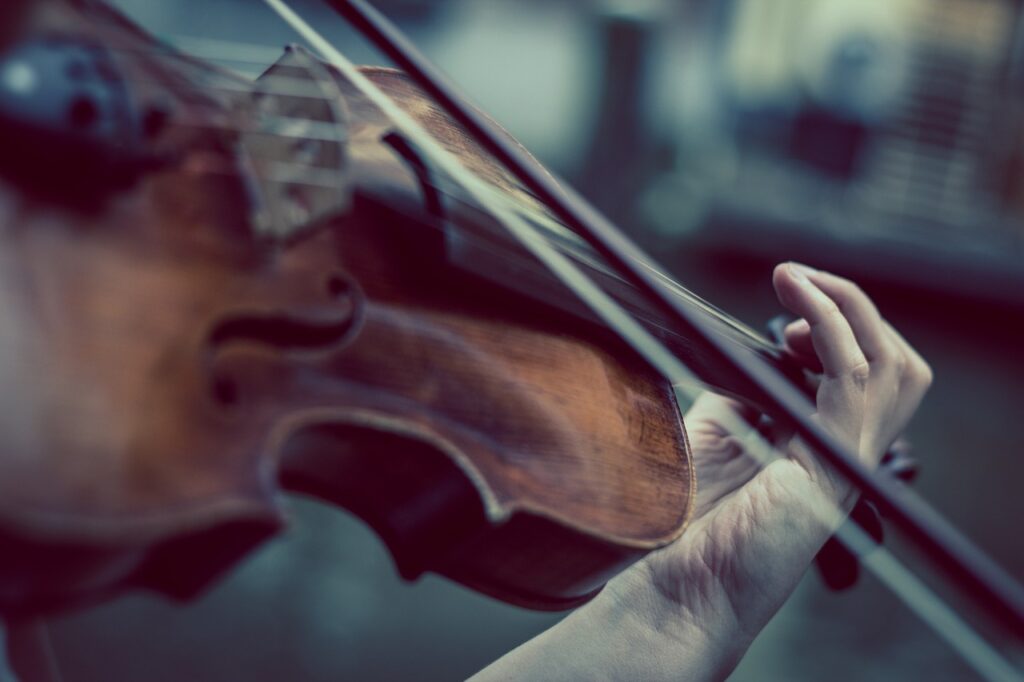 a hand holds a violin and bow
