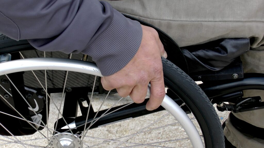 a close up of a hand holding the rim of a wheelchair