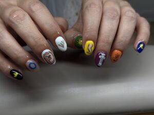 two hans with different colored nails and designs on each nail