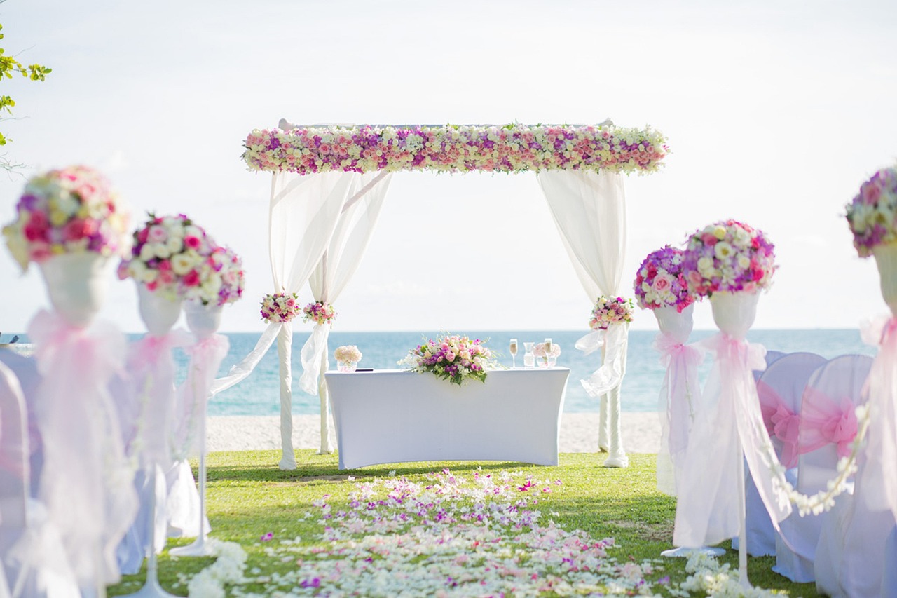 flowered chuppah at the end of an aisle