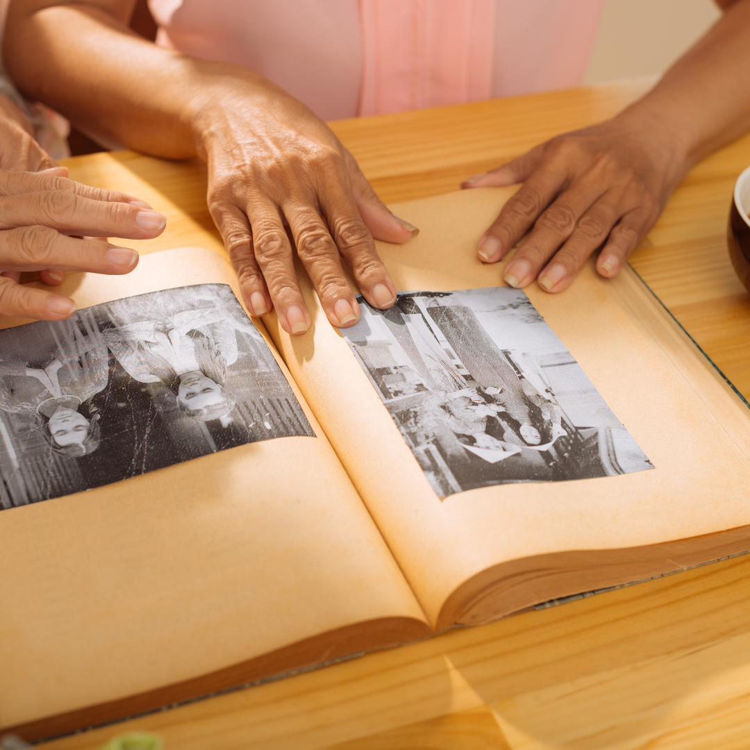 a person's hands going through a family album of old photos