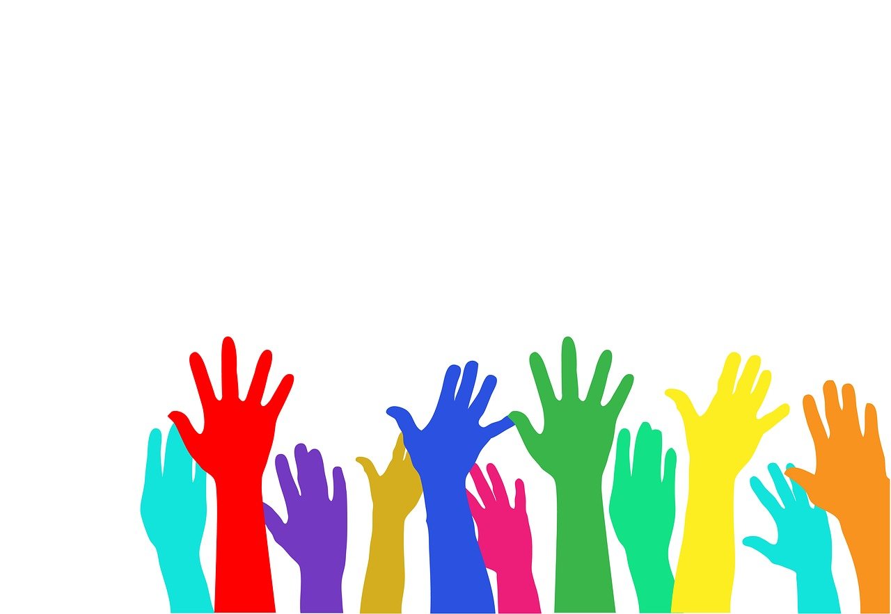 hands of different rainbow colors reach up against a white background