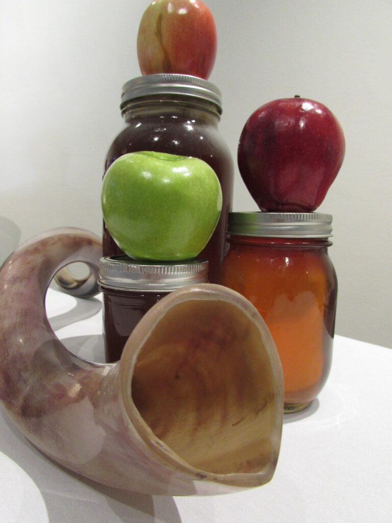 a shofar with jars of honey and apples