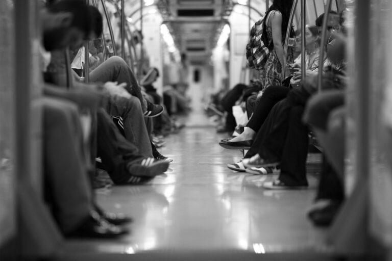 a black and white photo of people riding in a subway car