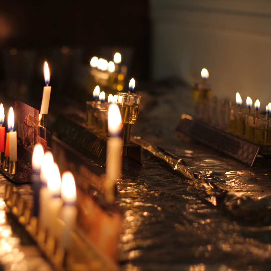 two hanukkah menorahs lit with candles