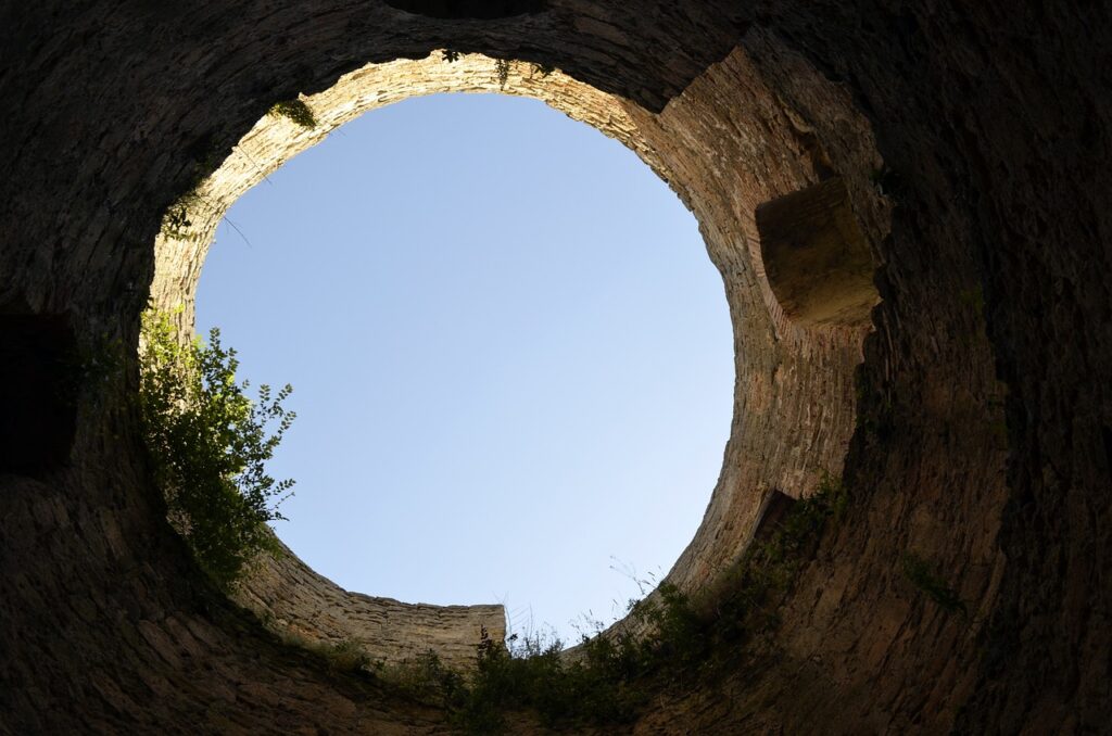 the sky through a circular window in a wall