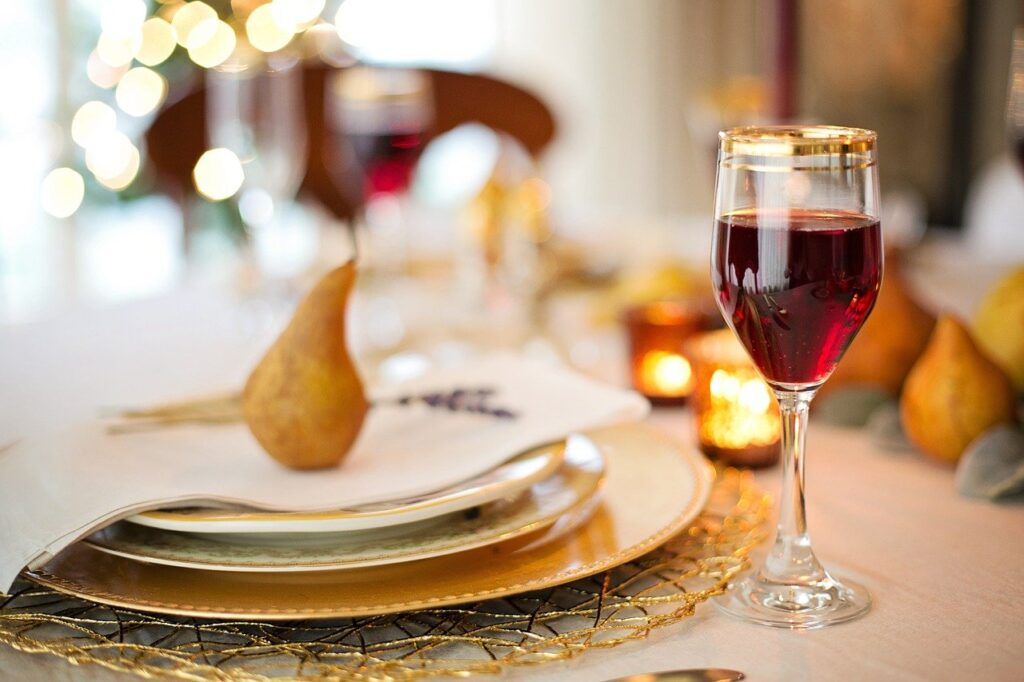 dining plates and a glass of red wine set on a table.