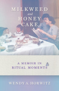 A family gathers at a table in a vintage photo on the cover of Milkweed and Honey Cake by Wendy A. Horwitz.