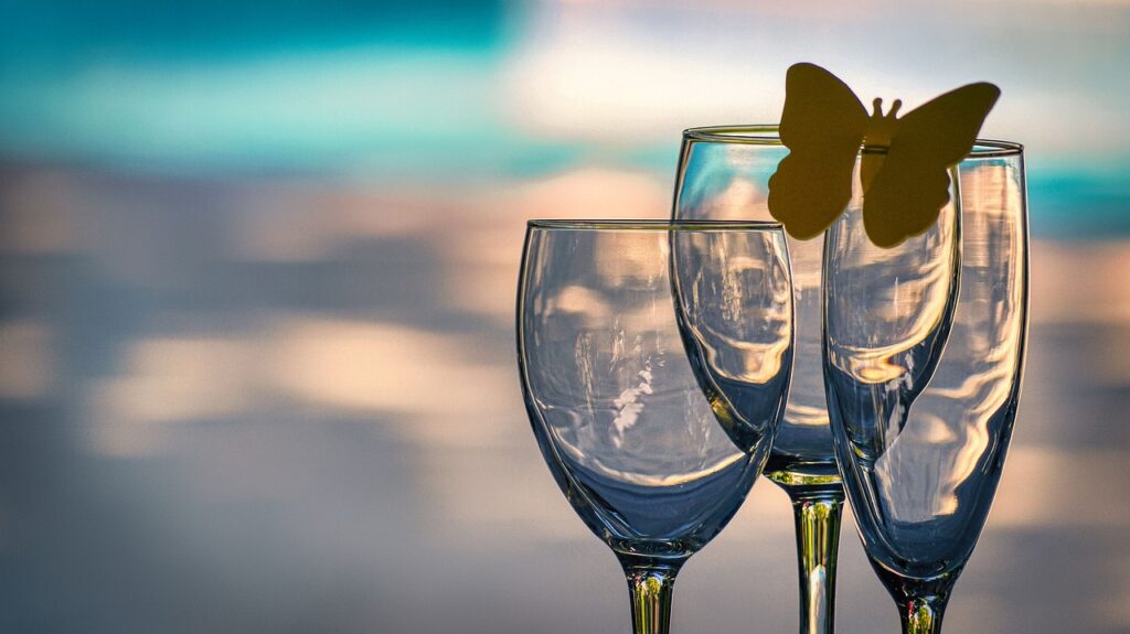 Three empty wine glasses with a yellow butterfly on one.